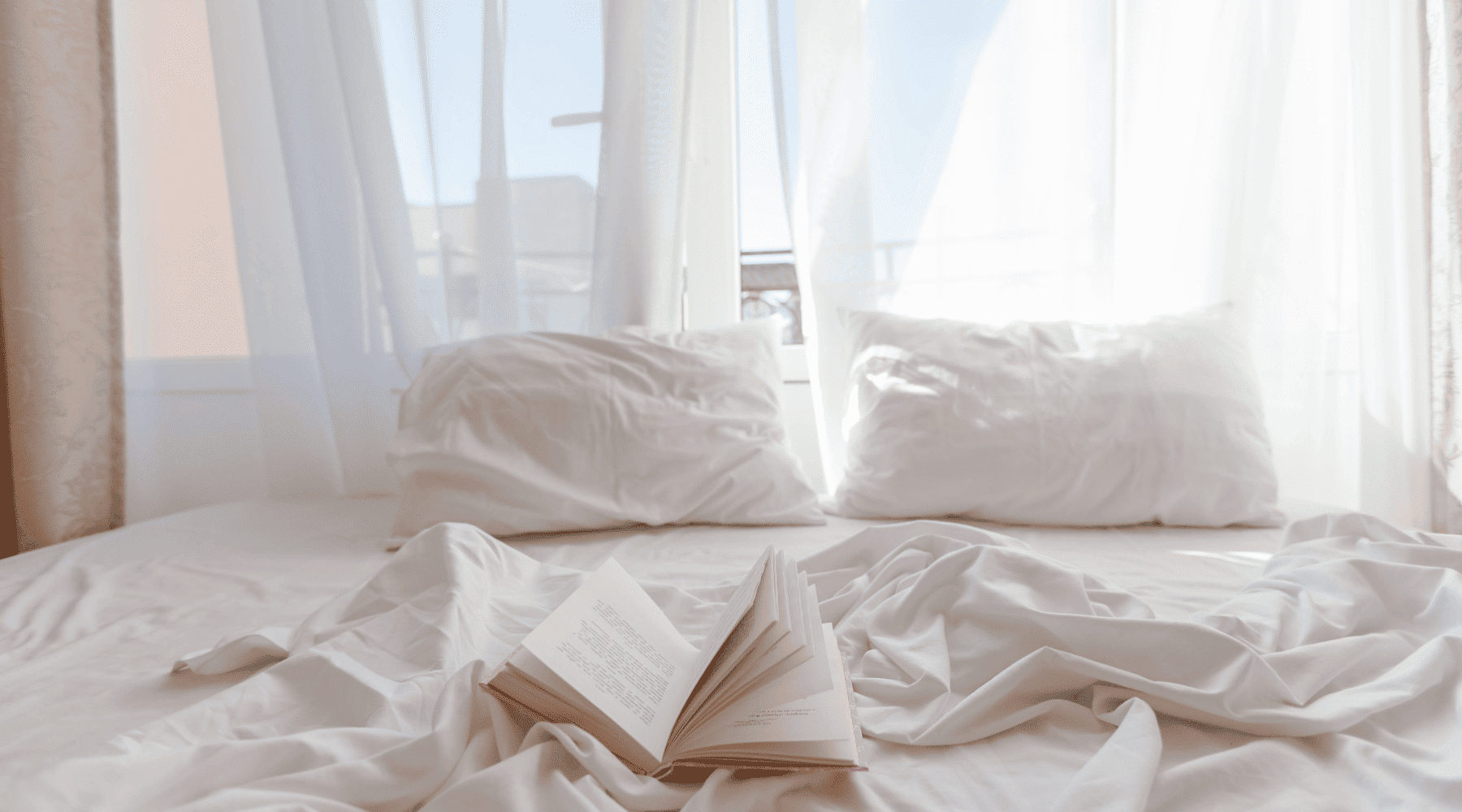 Weiße ägyptische Baumwoll-Betttwäsche mit Buch, luftig leicht im Sonnenlicht. Perfekt für schweißfreie Nächte